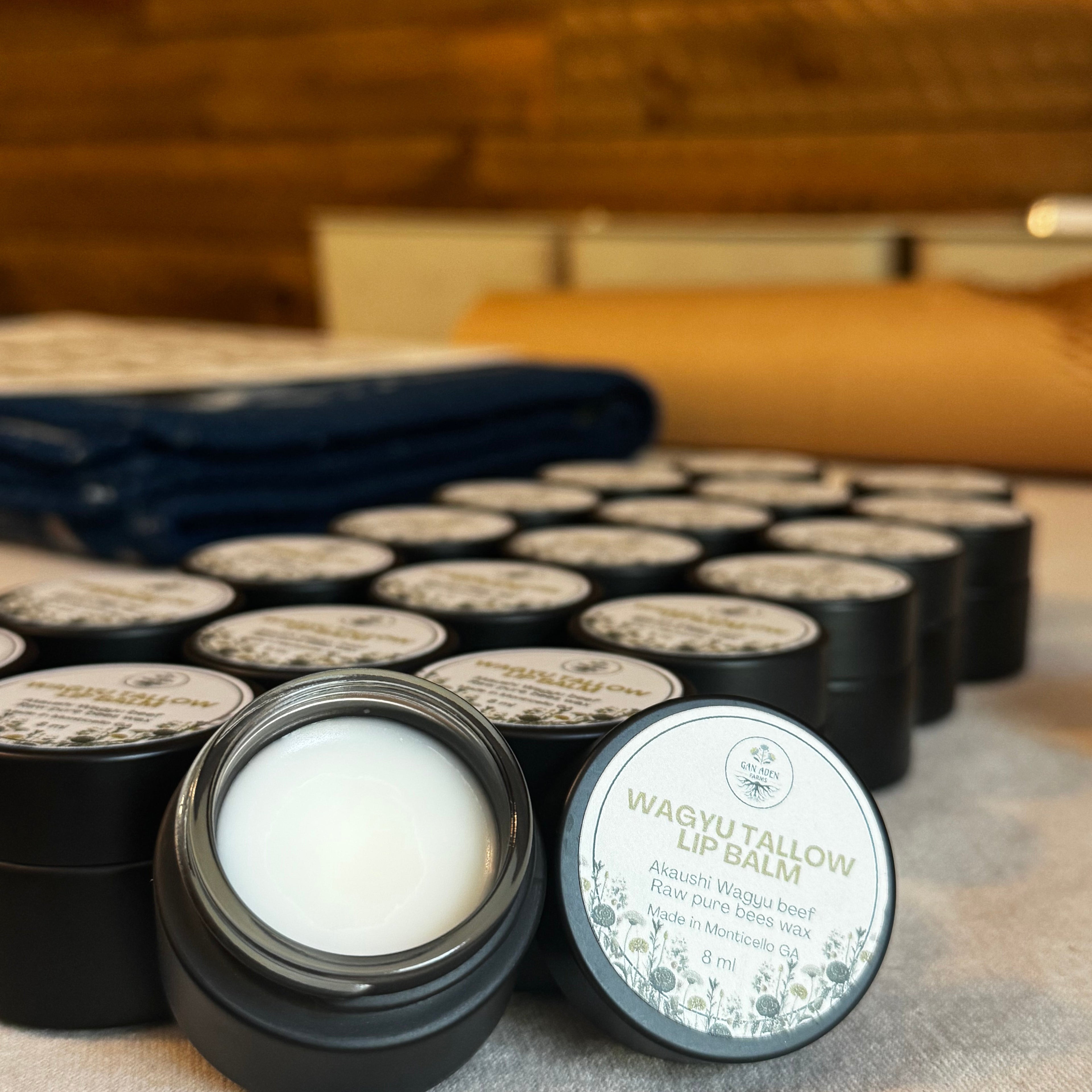Black lip balm containers with white wax on a wooden surface